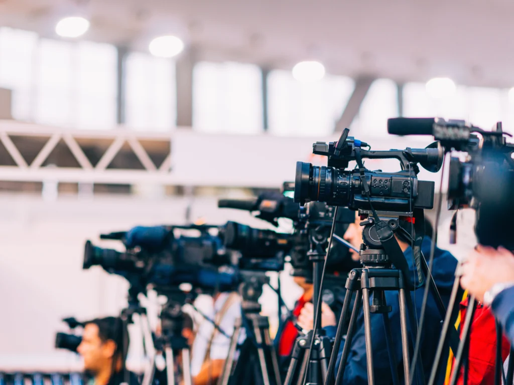 Mehrere professionelle Videokameras auf Stativen bei einer Pressekonferenz